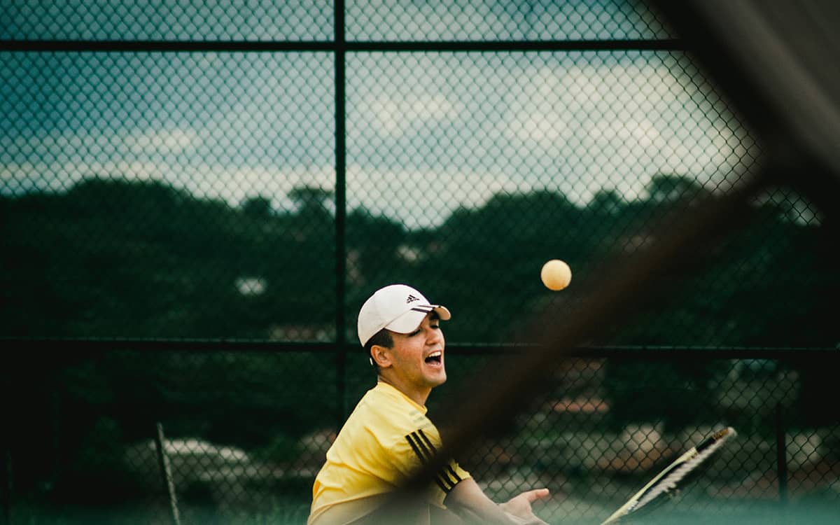 Badminton player hitting a shuttlecock on an outdoor court
